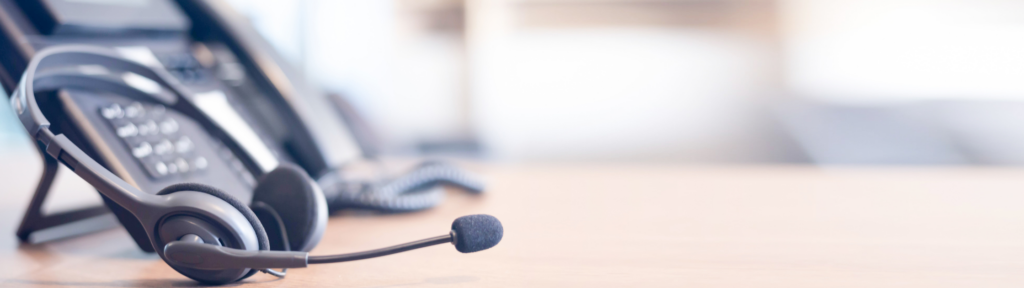 Image of headphones and phone in a call centre
